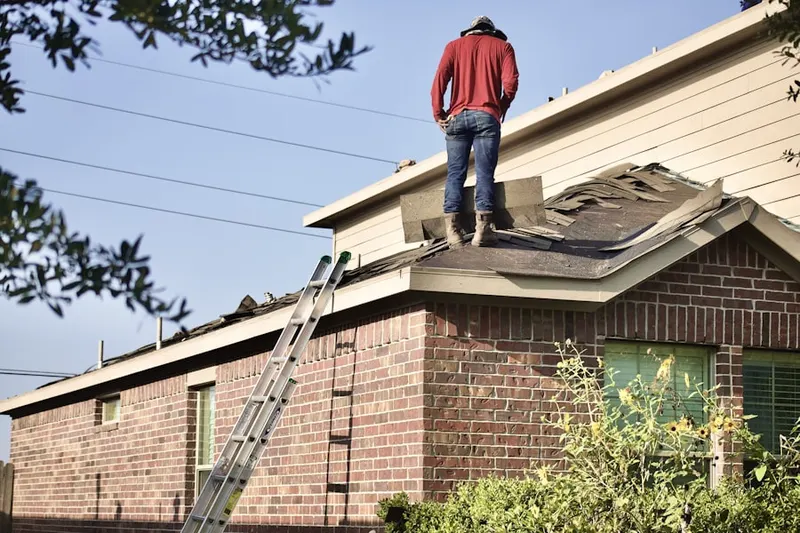 Professional roofer working on a residential roof in Bricksboro